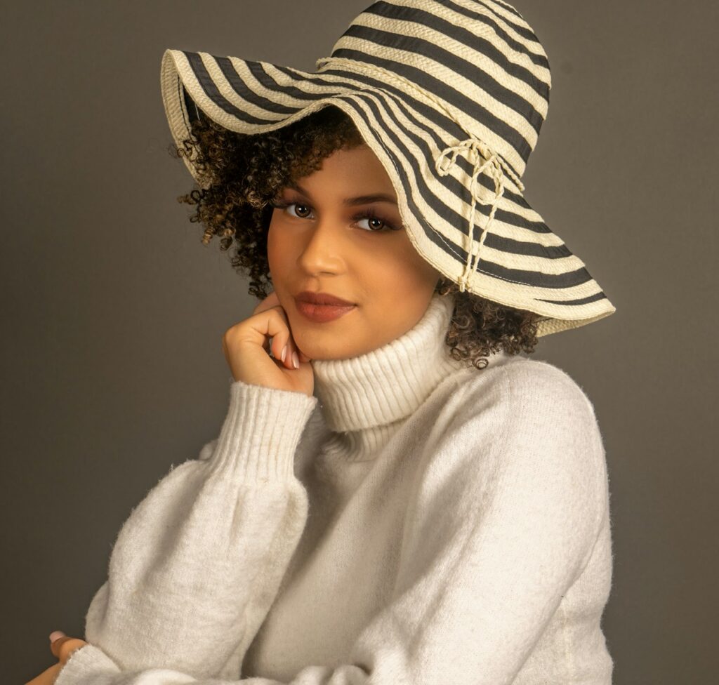 a woman in a white sweater and black and white hat
